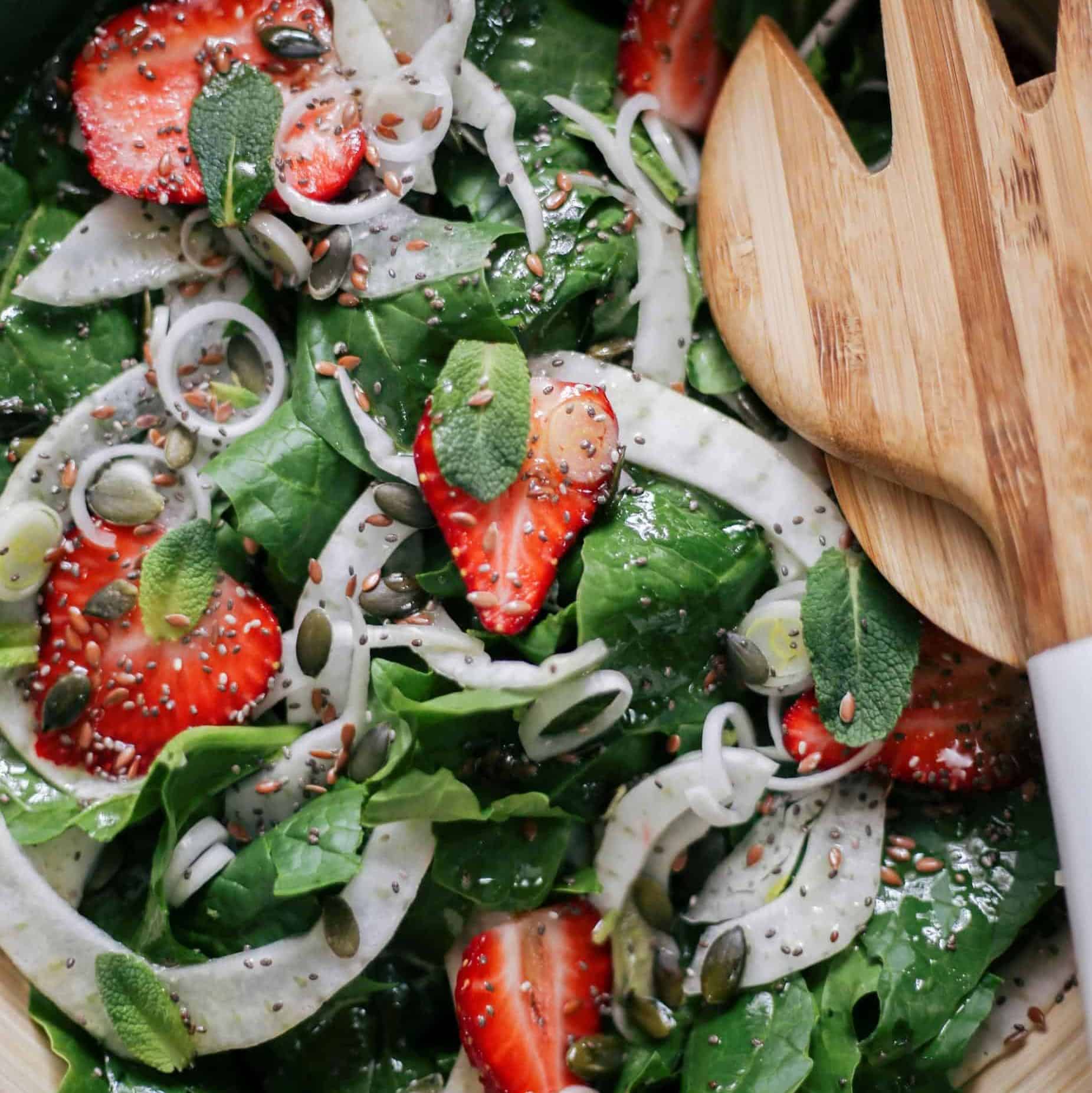 Appetizing spinach and strawberry salad including fennel and seeds, perfect for a healthy meal.