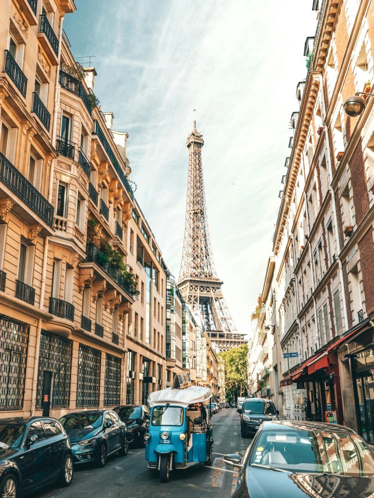 Charming Parisian street scene with the Eiffel Tower, cars, and classic architecture.