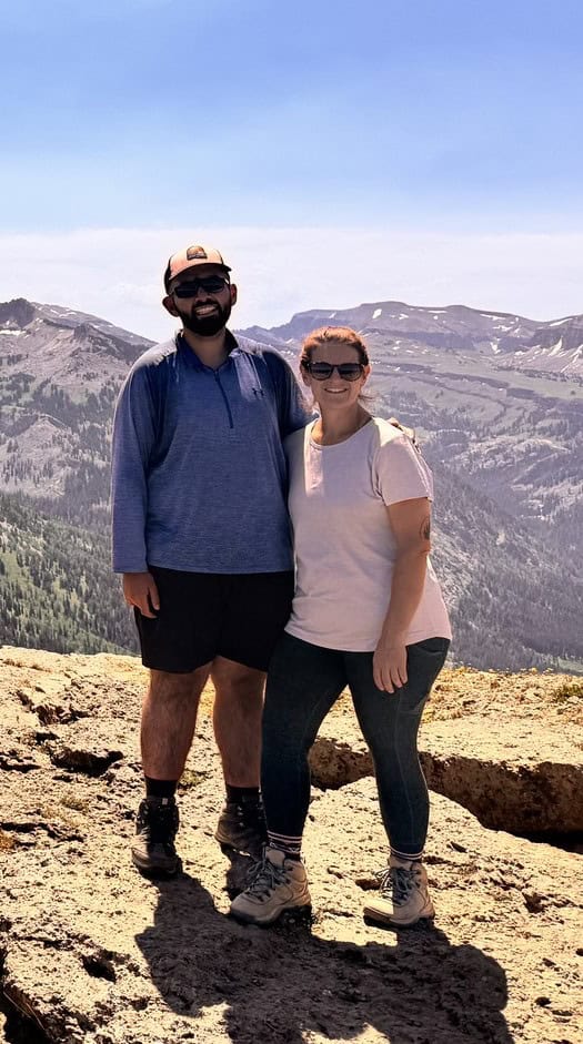 Man and woman in a mountain landscape in hiking gear.