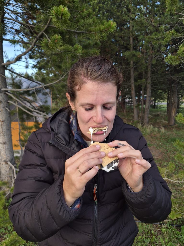 girl eating a delicious s'more with gooey marshmallow pull