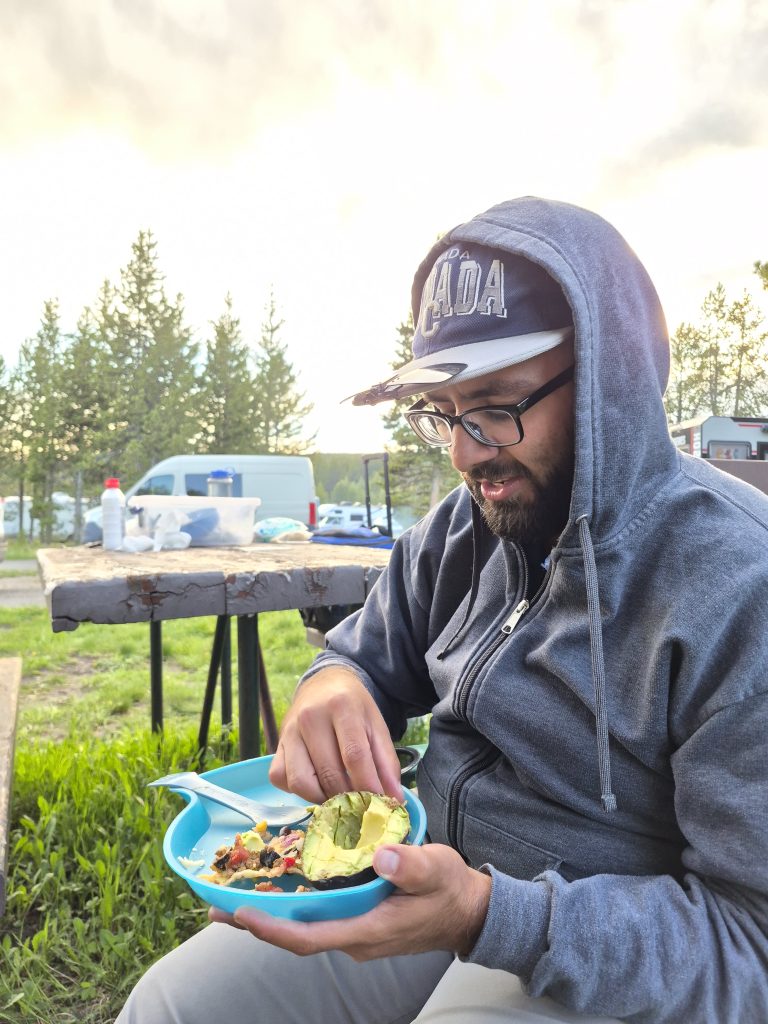 man eating campfire nachos while camping