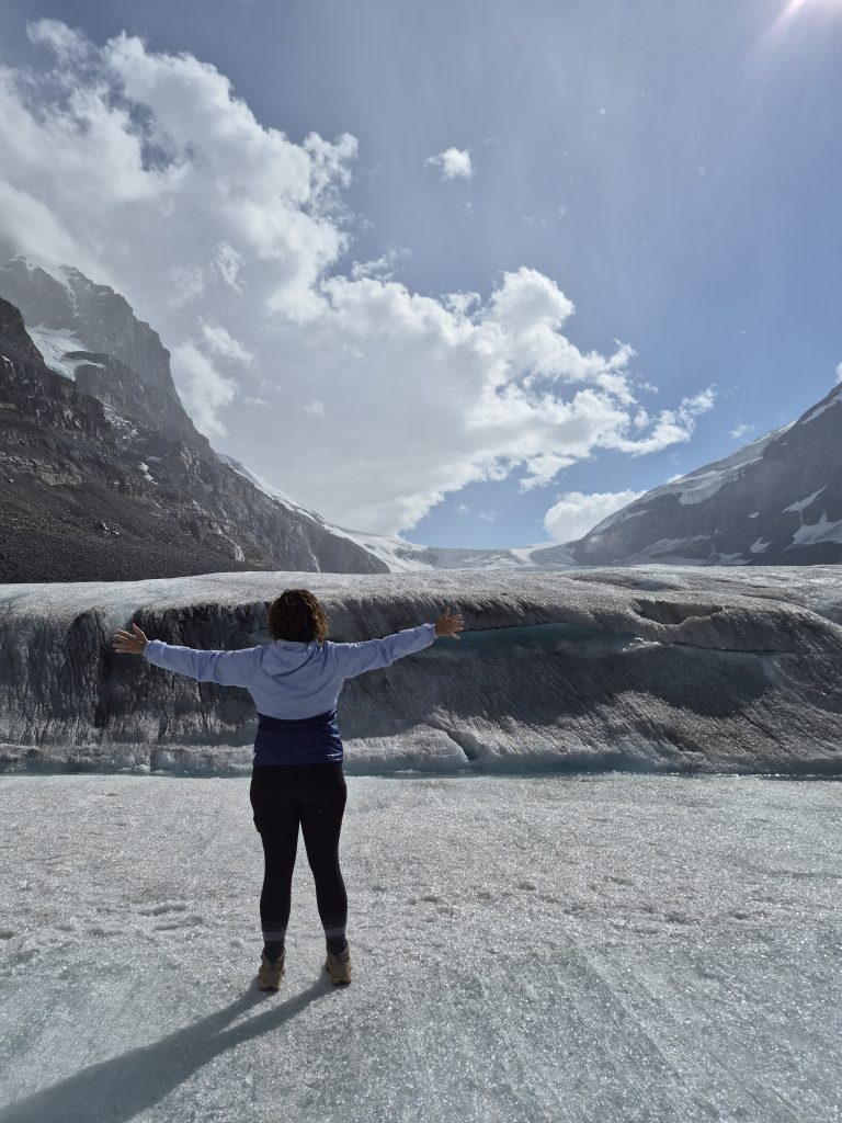 girl on a glacier wearing a purple rain jacket